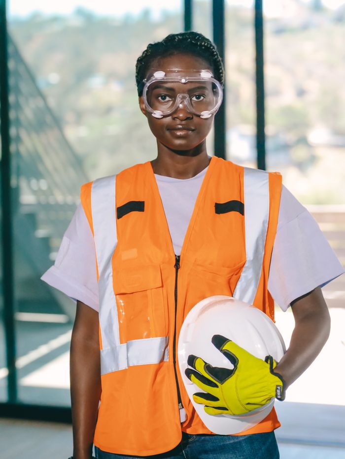 team-02 Engineer with safety gear and reflective vest standing indoors with hardhat